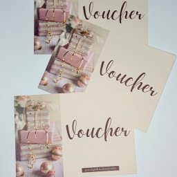Strefa Piękna Beauty Salon - Trzy vouchery na beżowym tle z motywem prezentów w odcieniach różu i złota oraz napisem 'Voucher' w kolorze brązowym, jeden z nich zawiera dodatkowo adres profilu salonu kosmetycznego.