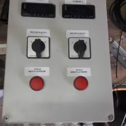 Panel sterowania z dwoma wyświetlaczami temperatury, przełącznikami trybu pracy (ręczny/auto) i czerwonymi przyciskami sygnalizującymi pracę wentylatorów, prawdopodobnie do kontroli klimatu...