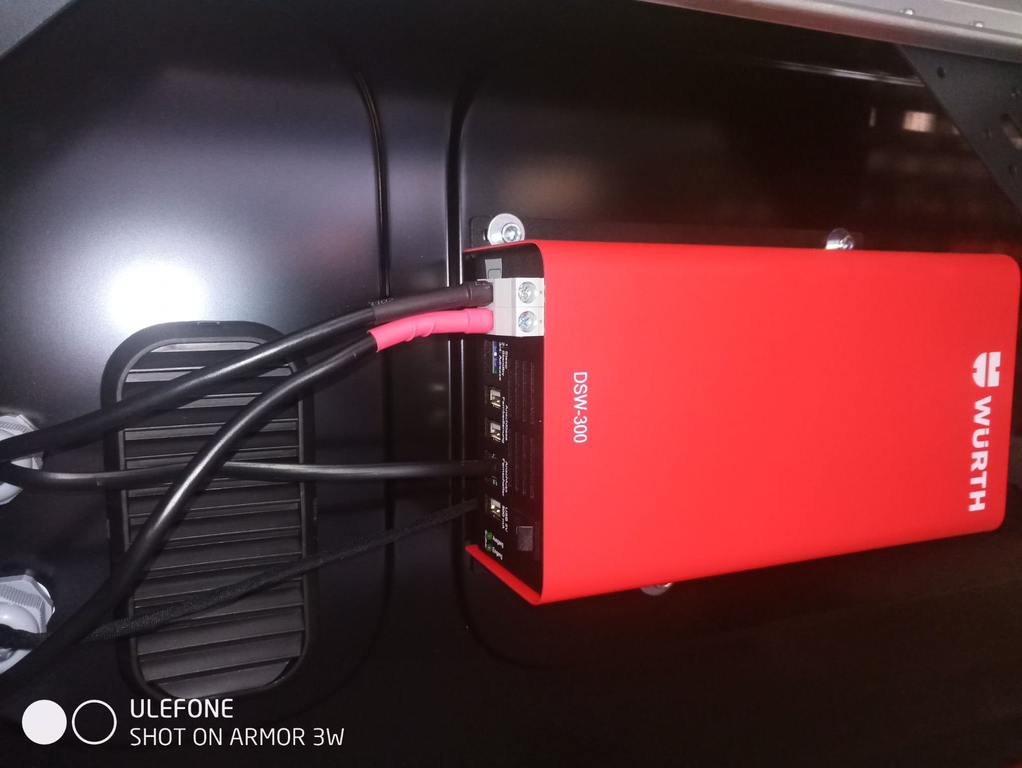 Czerwona skrzynka DSW-300 firmy Wurth zamontowana w czarnej obudowie z podłączonymi przewodami elektrycznymi.