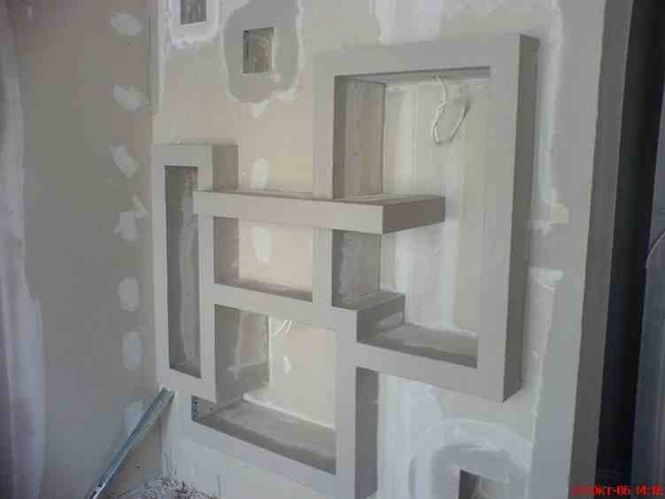 Nierówna ściana z geometryczną dekoracją wykonaną z płyty karton-gips, widoczne ślady szpachlowania i niedoskonałości wykończenia.