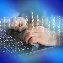 Osoba pisze na laptopie, nałożony efekt wizualizacji kodu binarnego w tle i na klawiaturze, tworząc wrażenie pracy z danymi lub programowaniem.