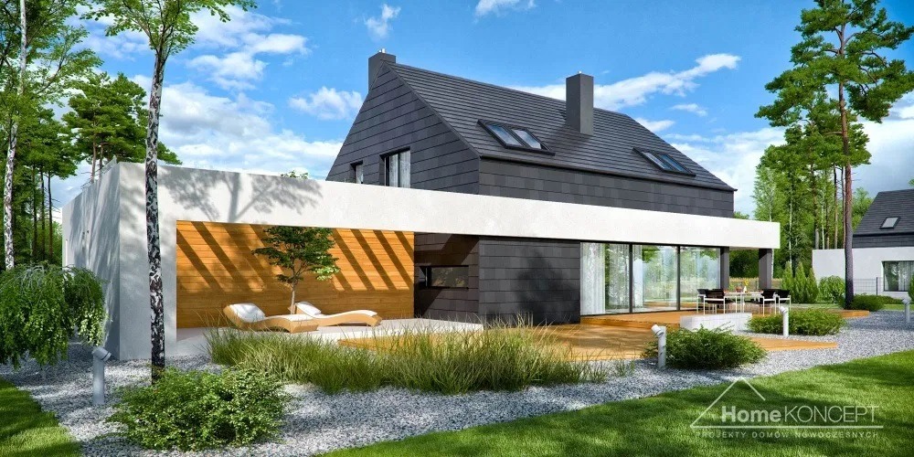 Nowoczesny dom szkieletowy z ciemną elewacją i jasnym elementem architektonicznym w Rakszawie, z widocznym tarasem, ogrodem i meblami ogrodowymi.