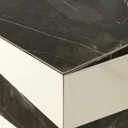 Połączenie płytek imitujących czarny marmur z białymi płytkami w łazience w Kłobucku, widoczne precyzyjne cięcie i łączenie na rogu ściany.