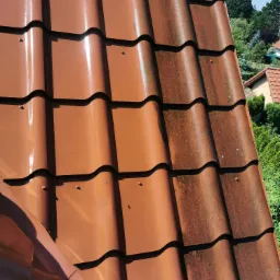 Częściowo wyczyszczony, brązowy dach z dachówki ceramicznej w Wisełce, ukazujący różnicę między czystą a zabrudzoną powierzchnią.