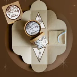 Rozłożone, beżowe opakowanie prezentowe z motywem świątecznym, pudełka z wieczkami i sznurki, widok z góry.