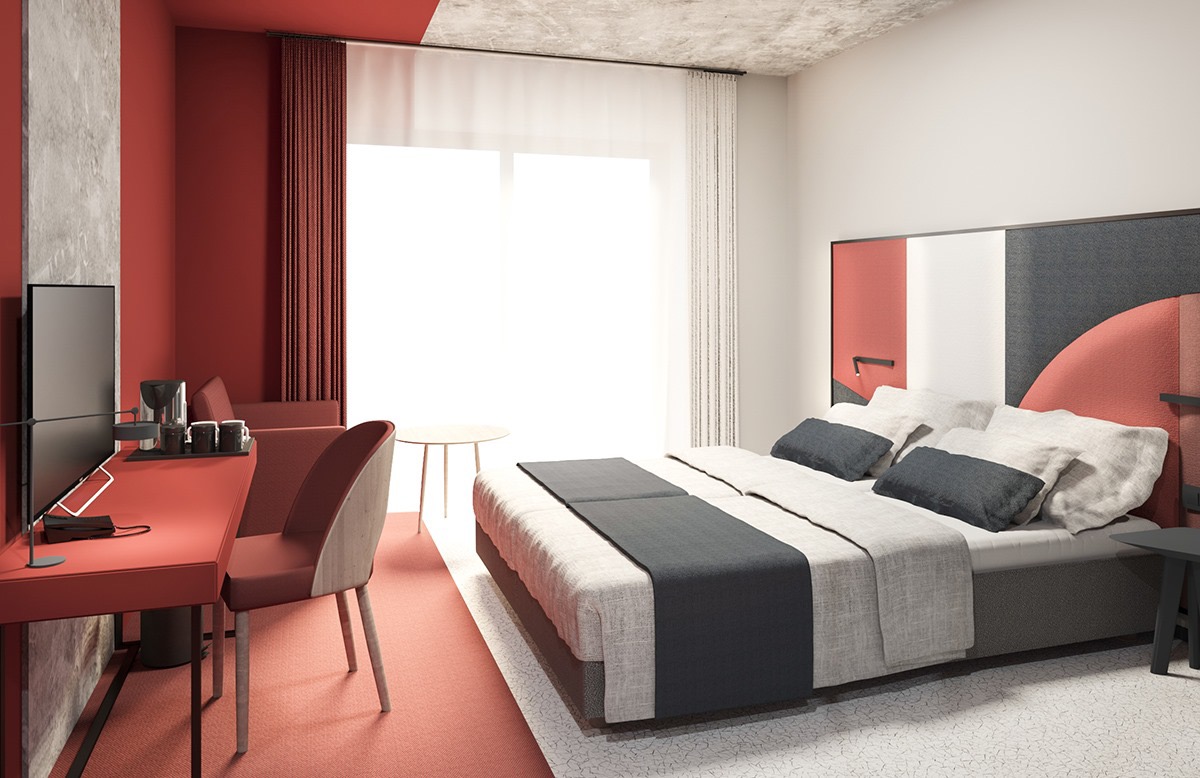 Nowoczesna aranżacja wnętrza pokoju hotelowego z czerwonymi akcentami, biurkiem z telewizorem, łóżkiem z szarymi poduszkami i małymi stolikami.