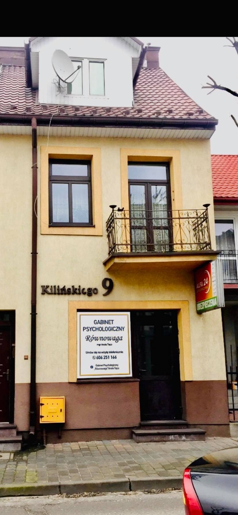 Fasada budynku z szyldem 'Gabinet Psychologiczny Równowaga' i adresem Kilińskiego 9. Nad wejściem balkon z ozdobną, metalową balustradą. Widoczny również szyld ubezpieczeniowy.
