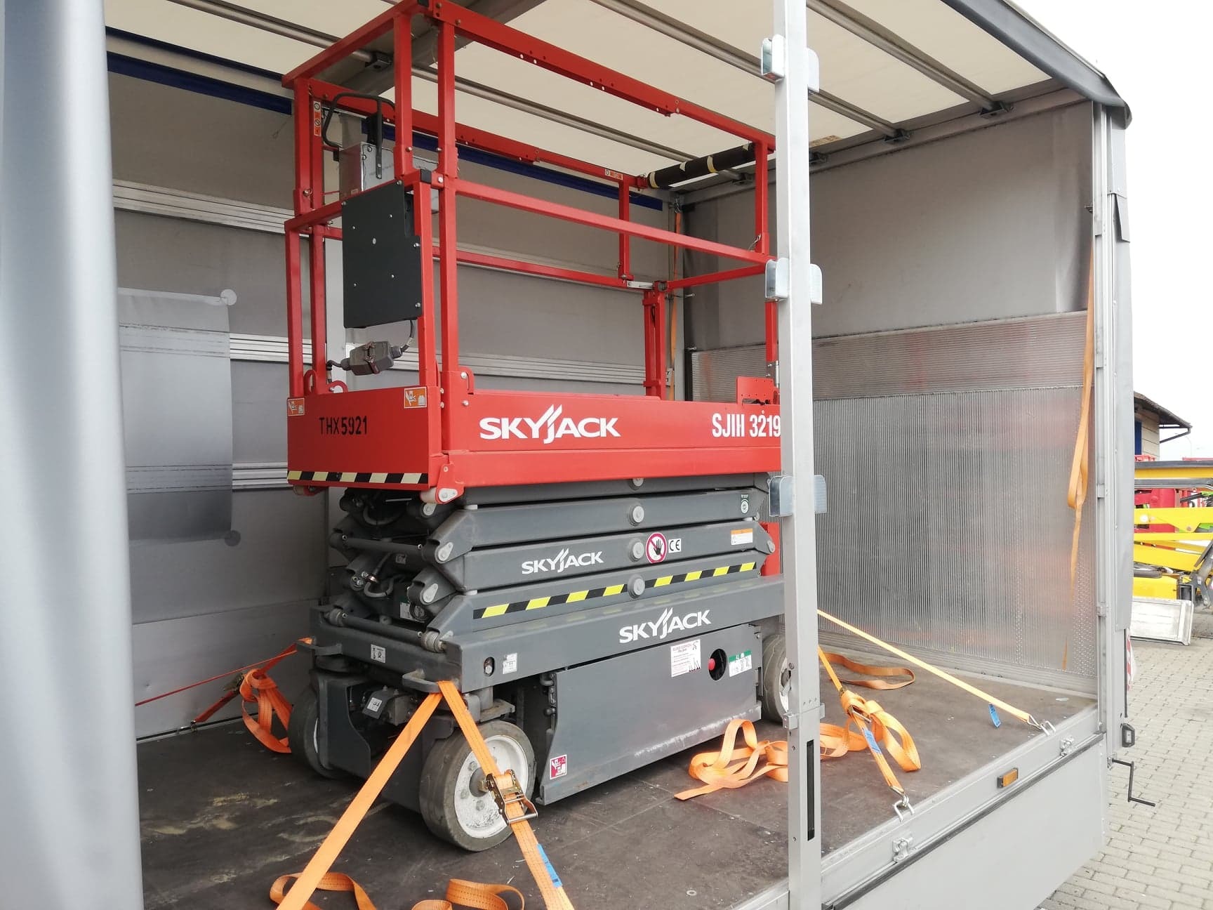 Podnośnik nożycowy Skyjack zabezpieczony pasami transportowymi wewnątrz przestrzeni ładunkowej pojazdu w Rzeszowie.