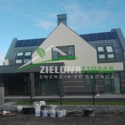 Zielonewolty.pl - Dom jednorodzinny w Połańcu z panelami słonecznymi na dachu, zamontowanymi przez Zieloną Firmę. Widoczne wiadra i resztki materiałów budowlanych sugerują niedawne zakończenie instalacji.