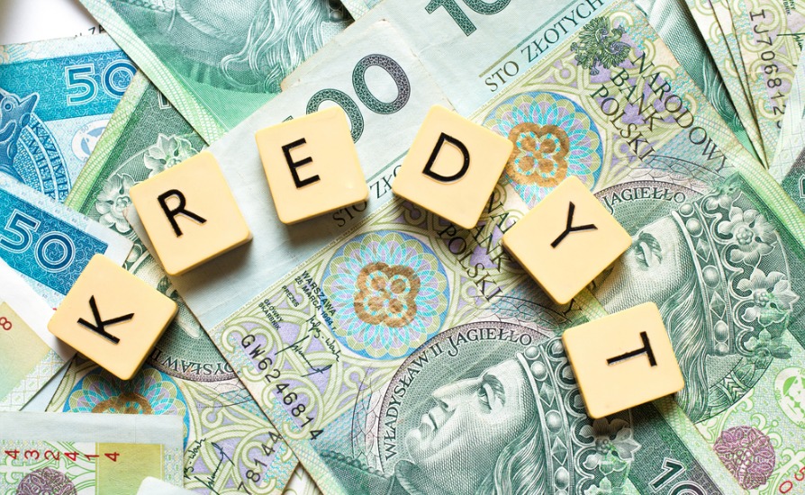 Polskie banknoty o nominałach 50 i 100 złotych, ułożone warstwami, z literami z gry słownej układającymi się w słowo 'KREDYT'.