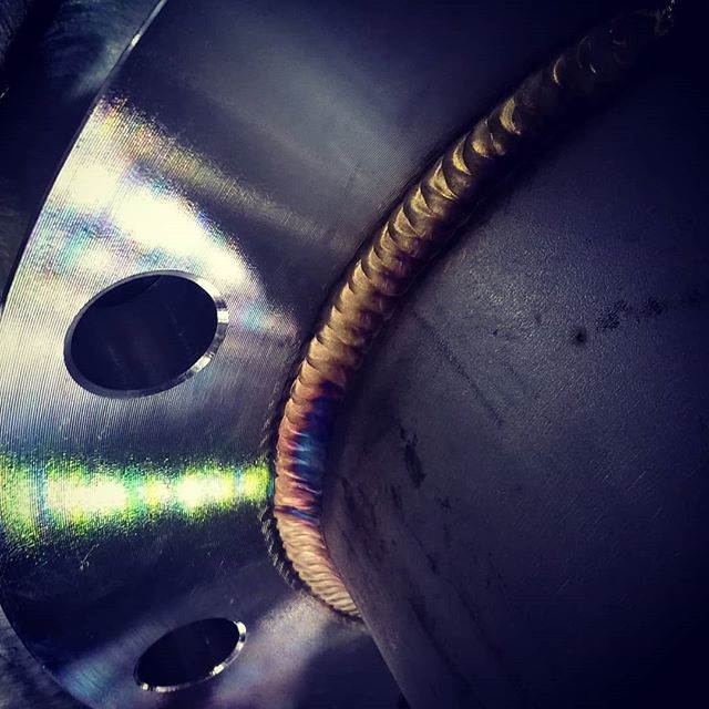 Spoina na okrągłym elemencie metalowym z widocznymi otworami, ukazująca charakterystyczne zabarwienie po procesie łączenia metali.