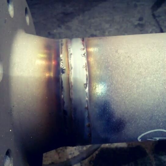 Spoina na metalowej rurze z widocznymi śladami ciepła i chłodzenia, wykonana z dużą precyzją.