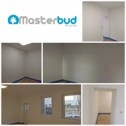 Kolaż zdjęć przedstawiający wnętrze świeżo pomalowanego na biało pomieszczenia z zabezpieczoną folią podłogą, logo firmy Masterbud i widok z okna na podwórze z materiałami budowlanymi.