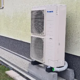 Panasonic HP 9kW 3-fazowy a za nim dom z instalacją opartą o kaloryfery.