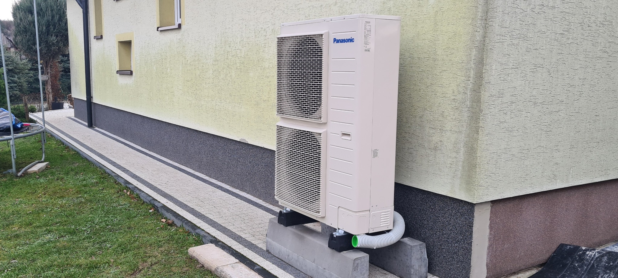 Panasonic HP 9kW 3-fazowy a za nim dom z instalacją opartą o kaloryfery.