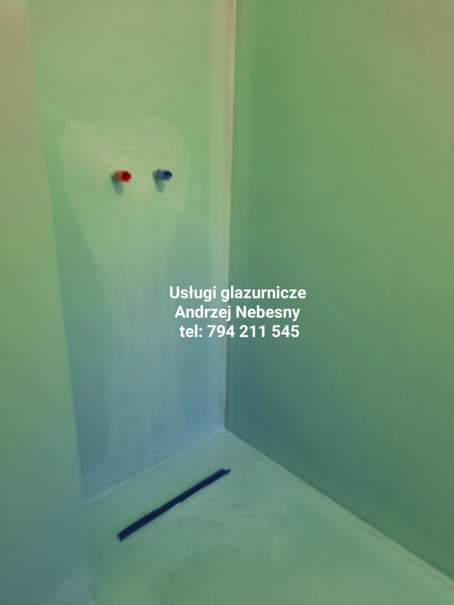 Świeżo uszczelniona kabina prysznicowa z odpływem liniowym, przygotowana do położenia płytek, widoczne wystające rury zasilające wodę.