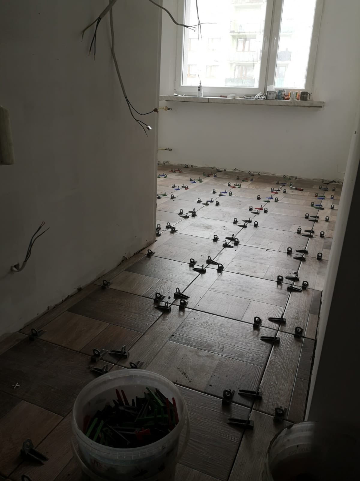 Zdjęcie zrobione podczas Kompletnego remontu mieszkania dla klienta na zdjęciu świeżo wykafelkowana kuchnia