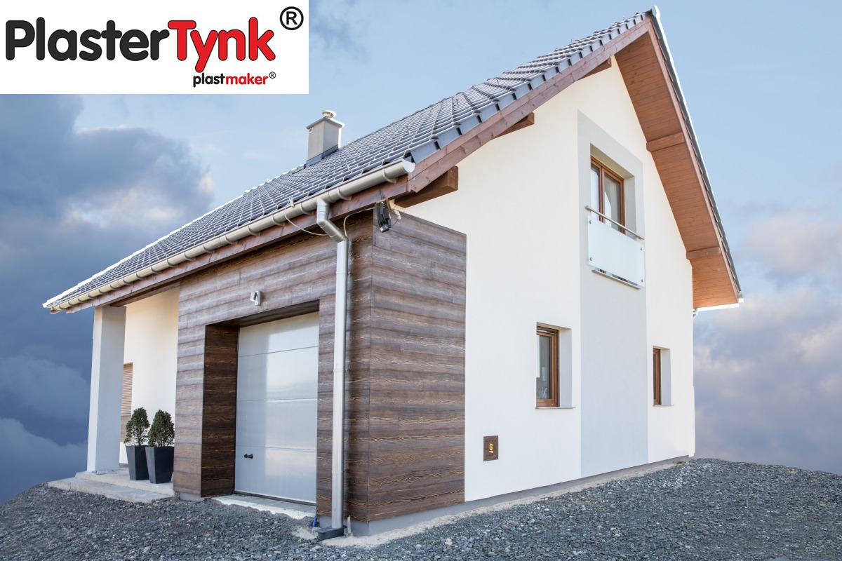 Nowoczesny dom jednorodzinny z białą elewacją i garażem wykończonym panelami imitującymi drewno, widoczny fragment dachu z szarą dachówką, logo producenta tynków w lewym górnym rogu.