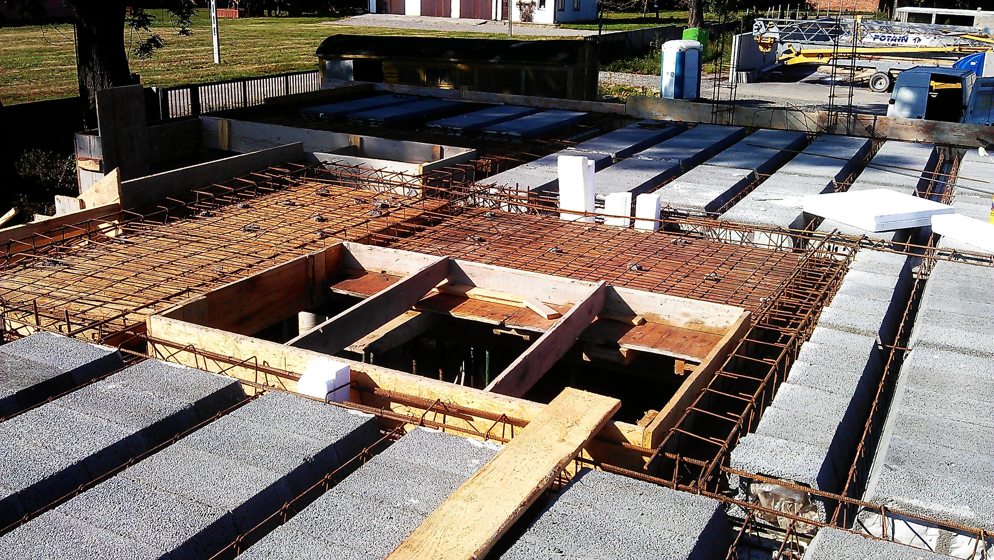 Wiązanie zbrojenia stropu Teriva na budowie domu jednorodzinnego z widocznym szalunkiem otworu na schody.