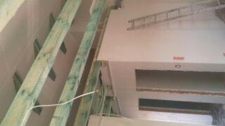 Ocieplone poddasze z widocznymi krokwiami i izolacją, przygotowane do wykończenia. Widoczna drabina oparta o ścianę.