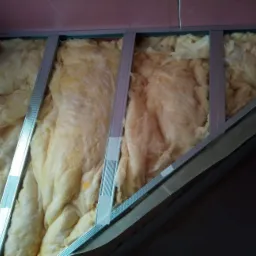 Konstrukcja metalowa pod płytę gipsowo-kartonową z izolacją z wełny mineralnej, widoczna na skośnej powierzchni poddasza.