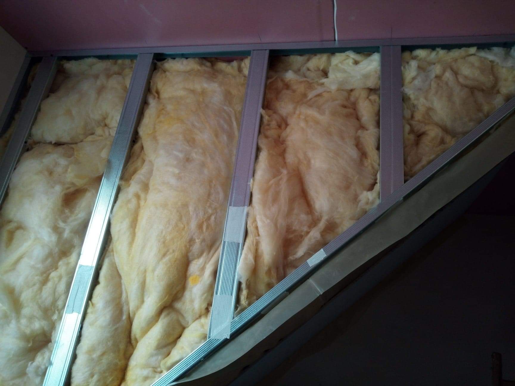 Konstrukcja metalowa pod płytę gipsowo-kartonową z izolacją z wełny mineralnej, widoczna na skośnej powierzchni poddasza.