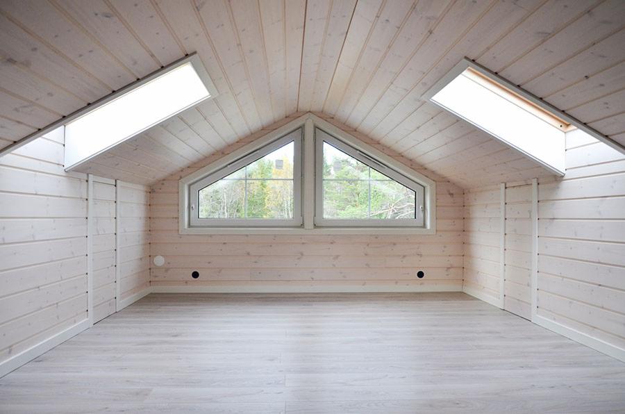 Poddasze wykończone jasnym drewnem, z dwoma oknami trójkątnymi pośrodku i dwoma oknami dachowymi po bokach, widok na drzewa za oknami, minimalistyczny styl.