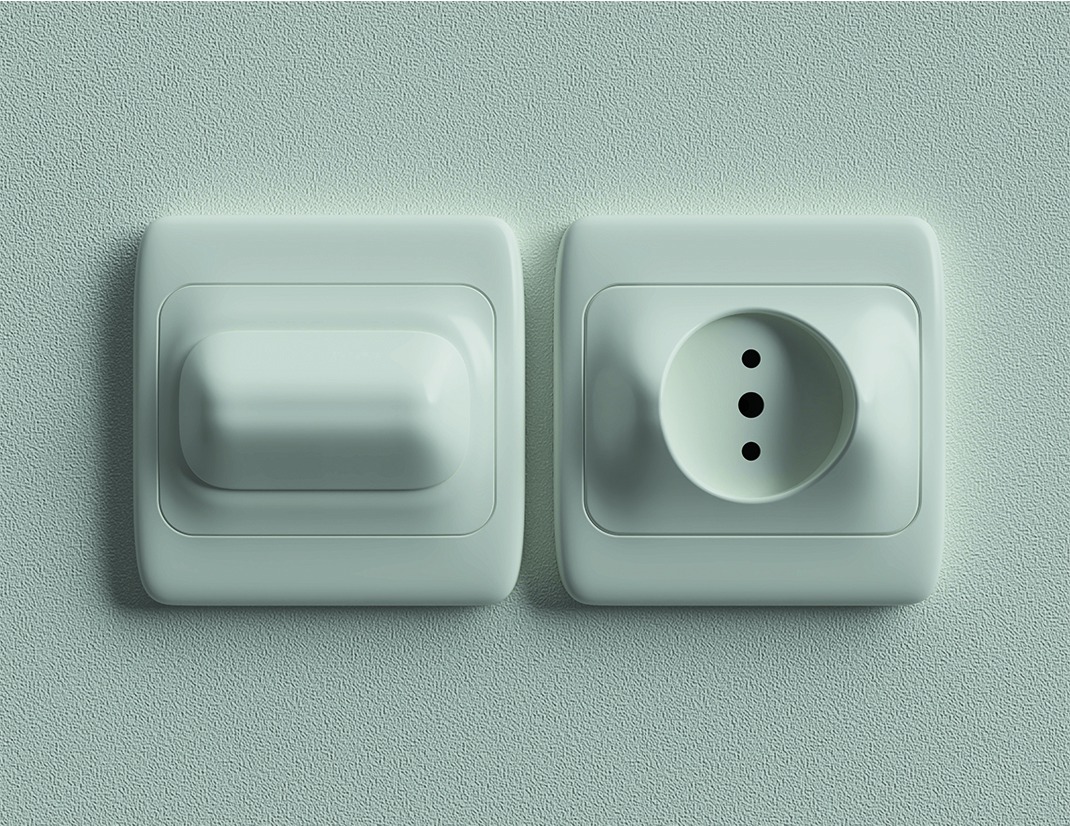 Białe gniazdko elektryczne i włącznik światła, zamontowane na jasnej, teksturowanej ścianie, widok z bliska.