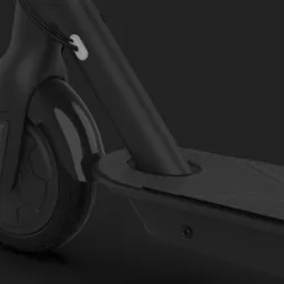 Szczegółowe ujęcie przedniego koła i podestu czarnej hulajnogi elektrycznej na ciemnym tle, ukazujące detale bieżnika opony i antypoślizgowej powierzchni podestu.