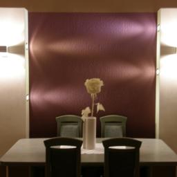 MABEKO Usługi Remontowo-Wykończeniowe - Jadalnia z fioletową ścianą, oświetleniem punktowym i kwiatem w wazonie na stole, widok z przodu na cztery krzesła.