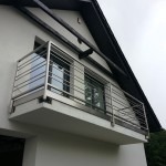 Balkon z nowoczesną, metalową konstrukcją zabezpieczającą, widok z dołu.