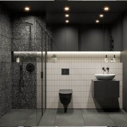 UO Mariusz Baron - Nowoczesna łazienka w ciemnej kolorystyce z kabiną prysznicową wykończoną płytkami lastryko, wiszącą miską WC i umywalką nablatową na szafce.