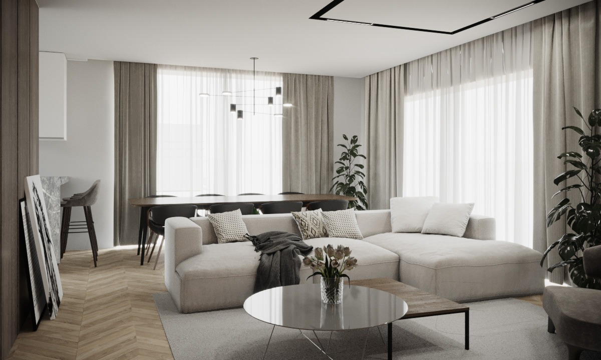 Jasne, przestronne wnętrze salonu z narożną sofą, okrągłym stolikiem kawowym z kwiatami, dużym oknem z zasłonami, lampą sufitową i parkietem w jodełkę.