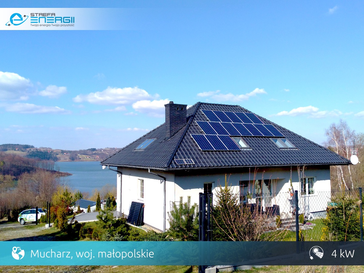 Dom jednorodzinny z panelami słonecznymi na dachu, widok na jezioro Mucharskie w tle, lokalizacja Mucharz, województwo małopolskie.