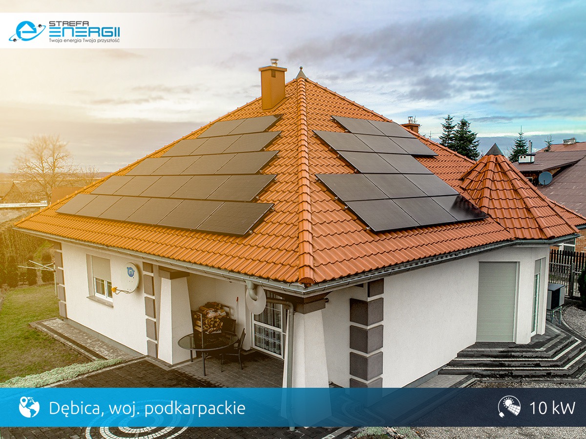 Dom jednorodzinny z panelami słonecznymi na pomarańczowym dachu, widok z góry, błękitne niebo, Dębica, Podkarpacie, moc instalacji 10kW.