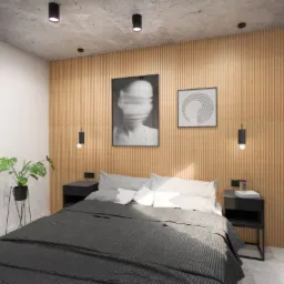 Nowoczesna sypialnia z łóżkiem z szarą narzutą, drewnianą ścianą z pionowymi panelami, czarnymi szafkami nocnymi i minimalistycznymi lampami wiszącymi. Na ścianie grafiki w czarnych ramkach.