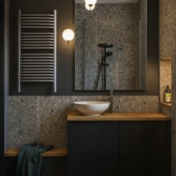 Sowa Design Projekty Wnętrz - Nowoczesna łazienka w ciemnych barwach z drewnianymi akcentami. Umywalka nablatowa, grzejnik drabinkowy, lustro odbijające kabinę prysznicową. Minimalistyczny design.