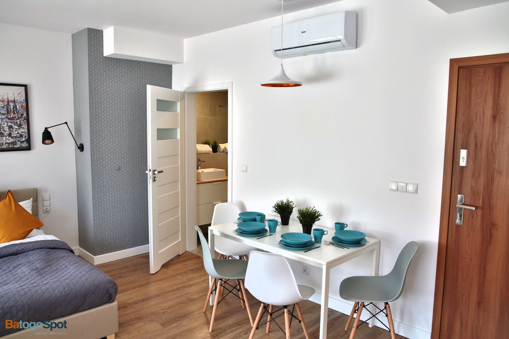 Nowoczesny apartament z jadalnią, widok na łazienkę przez otwarte drzwi, klimatyzacja na ścianie i dekoracyjne oświetlenie.