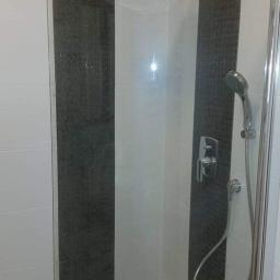 Milena - Nowoczesna kabina prysznicowa z deszczownicą i słuchawką, wykończona białymi i grafitowymi płytkami w pionowe pasy.