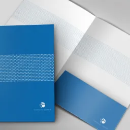Niebieski folder firmowy Financial Center z białym logo i paskiem z drobnymi kropkami, otwarty obok zamkniętego, prezentacja identyfikacji wizualnej.