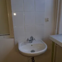 Montaż umywalki wraz z baterią, przyłącza zimnej i ciepłej wody., wykończenie powierzchni ściany glazurą.