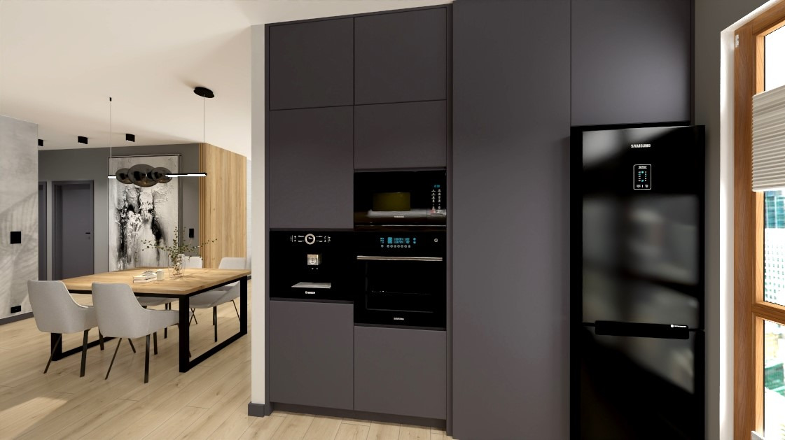Nowoczesna kuchnia z zabudową w odcieniach szarości, z czarnym sprzętem AGD (lodówka, piekarnik, ekspres do kawy). Drewniany stół z krzesłami w tle.