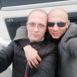 Non stop car - Dwaj mężczyźni obejmujący się na tle białej kabiny ciężarówki z widocznym logo 'H3' na grillu.