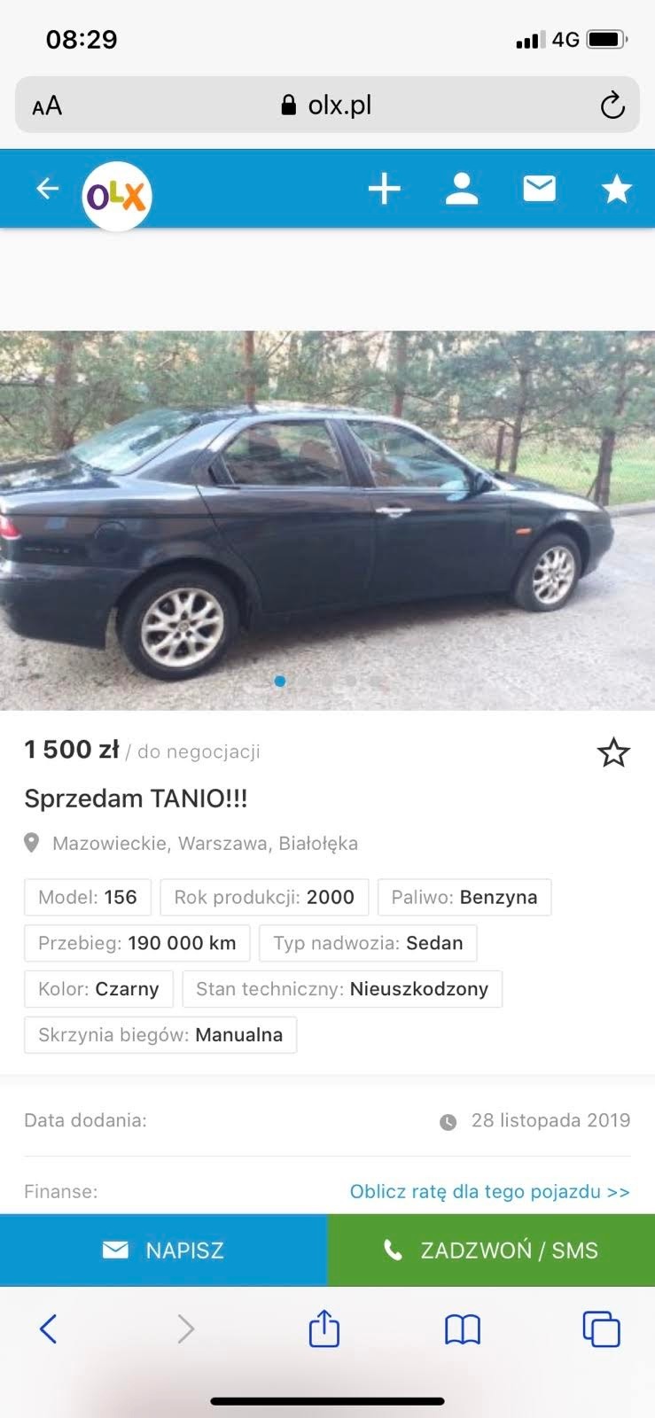Czarny sedan Alfa Romeo 156, rocznik 2000, sfotografowany z boku na tle drzew, prezentowany na zrzucie ekranu z ogłoszenia OLX.