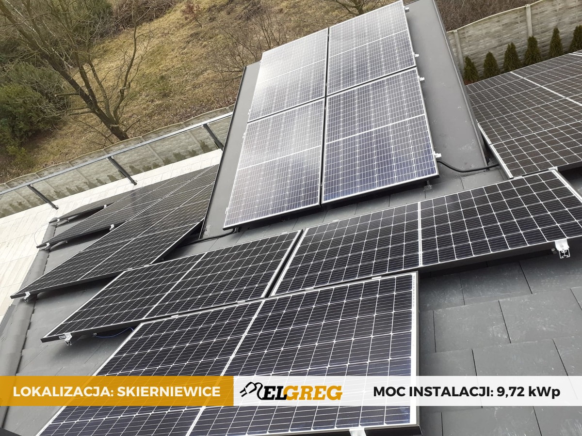 Instalacja paneli fotowoltaicznych na ciemnym, spadzistym dachu, widok z góry, częściowo pochmurne niebo w tle, widoczny napis 'Lokalizacja: Skierniewice' oraz logo firmy i informacja 'Moc...