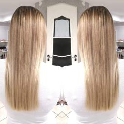 Salon fryzjerki Ewa Classic - Długie, proste włosy blond z ciemniejszym odrostem, widok z tyłu, symetryczne ujęcie z drzwiami w tle.