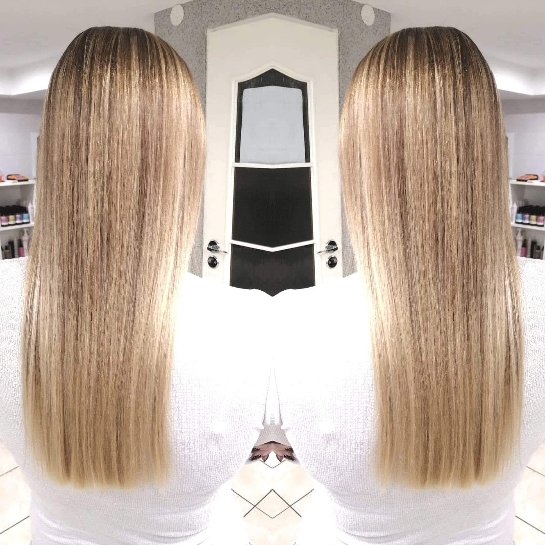 Długie, proste włosy blond z ciemniejszym odrostem, widok z tyłu, symetryczne ujęcie z drzwiami w tle.