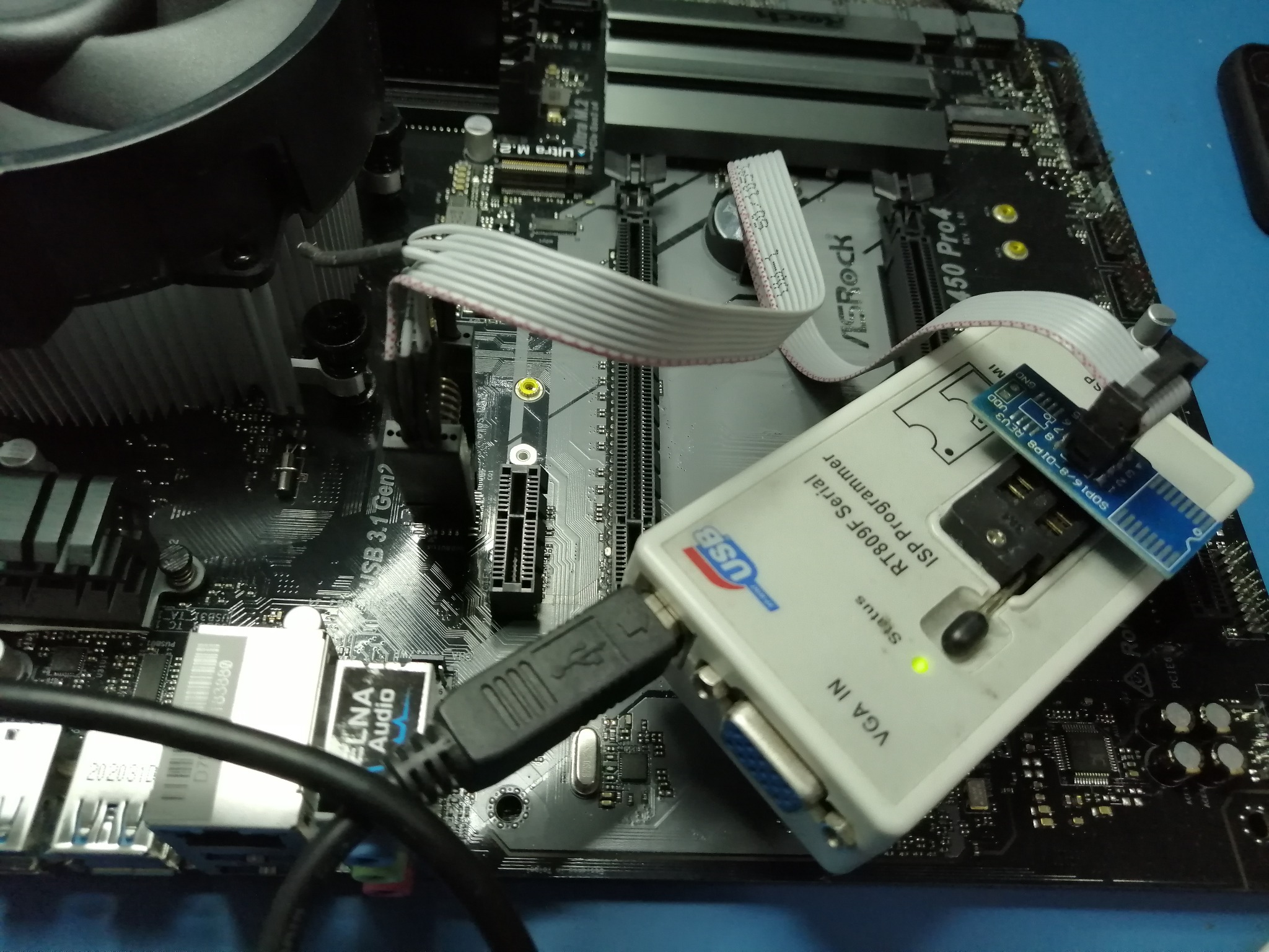 Programator RT809F Serial ISP podłączony przez USB do płyty głównej ASRock 450 Pro4, z podpiętym układem scalonym SOP16/8-DIPS REU3, sygnalizujący status diodą LED.