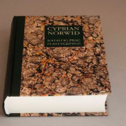 Książka Cypriana Norwida, katalog prac plastycznych, z marmurkową okładką w odcieniach brązu i czerni, oprawiona w ciemnozieloną skórę.