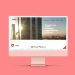 Ekran komputera iMac wyświetlający stronę internetową kancelarii prawnej z nowoczesnym designem, w tle budynek biurowy w promieniach słońca, minimalistyczny interfejs użytkownika.